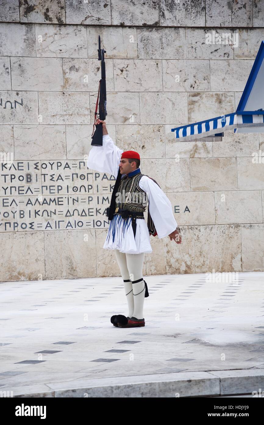 Un Evzone mantiene la sua pistola aloft al cambio della guardia ad Atene Foto Stock