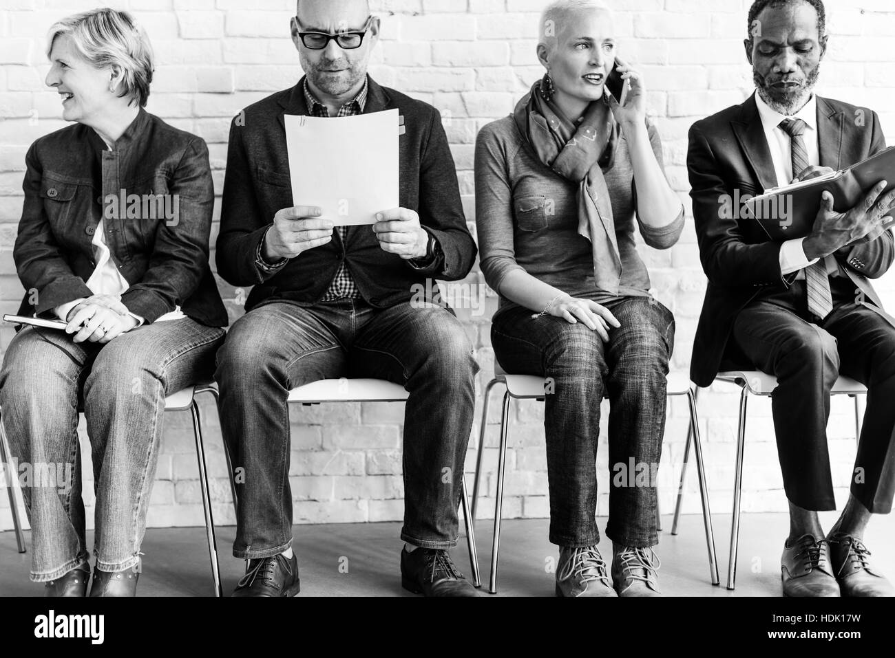 Diversi gruppi di persone in comunità seduta in attesa della nozione Foto Stock