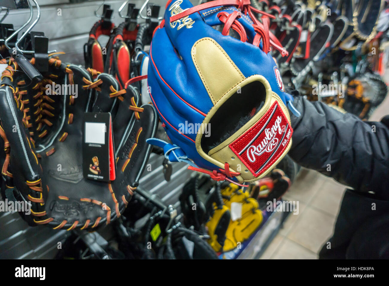 Un acquirente detiene un marchio Rawlings Guanto baseball in un negozio di articoli sportivi a New York il Mercoledì, 7 dicembre 2016. Dovuto alla diminuzione della partecipazione negli sport di squadra dai giovani le vendite di articoli sportivi hanno colpito registrare i minimi. Sei a 17 anni gira demografica verso la tecnologia e i videogiochi. Newell Marchi è segnalato per essere interessati a vendere il suo marchio Rawlings. (© Richard B. Levine) Foto Stock