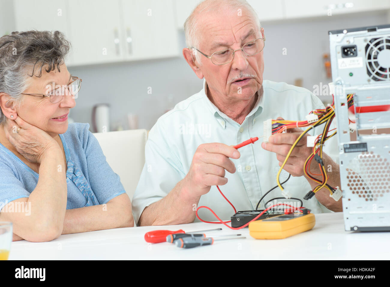 Uomo in pensione il computer di test con multimetro Foto Stock