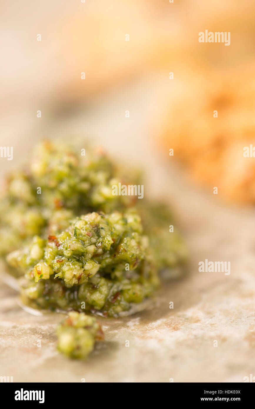 Il verde il pesto in extreme close up. Fatta di foglie di basilico fresco. La cucina tradizionale italiana. Foto Stock