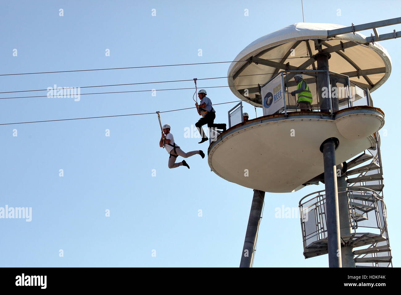 Due gents tenendo il salto della fede inizio il filo zip discesa dalla torre sul molo di Bournemouth per la stazione spiaggia! Foto Stock