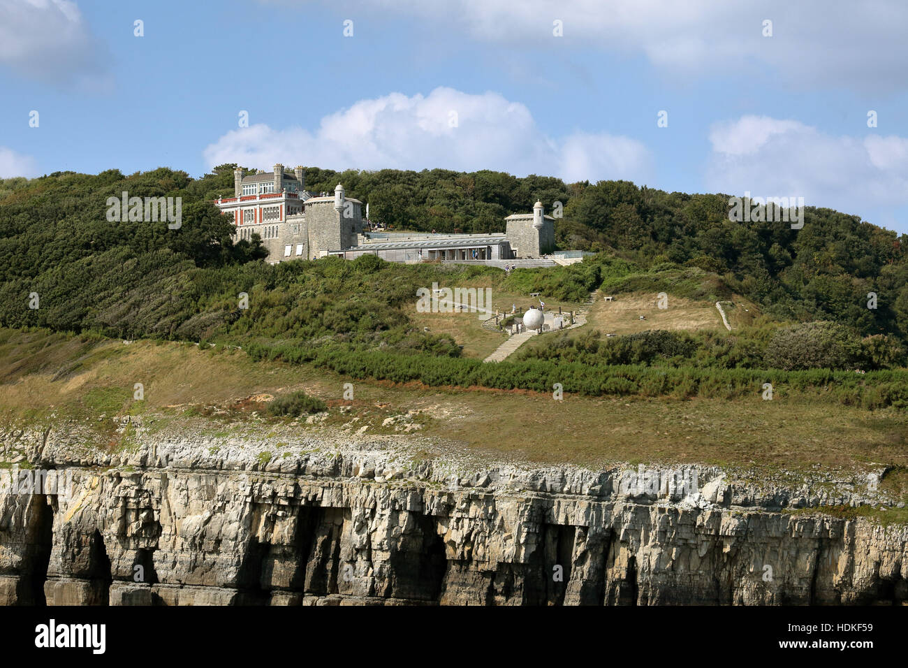 Visitatori godendo il sole autunnale a durlston country park e il castello con il grande globo in primo piano DORSET REGNO UNITO Foto Stock
