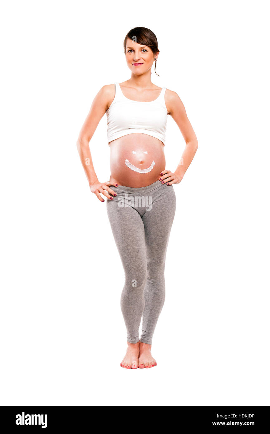 Donna incinta con crema di sun sul ventre, isolato su sfondo bianco. Coppy spazio. Foto Stock
