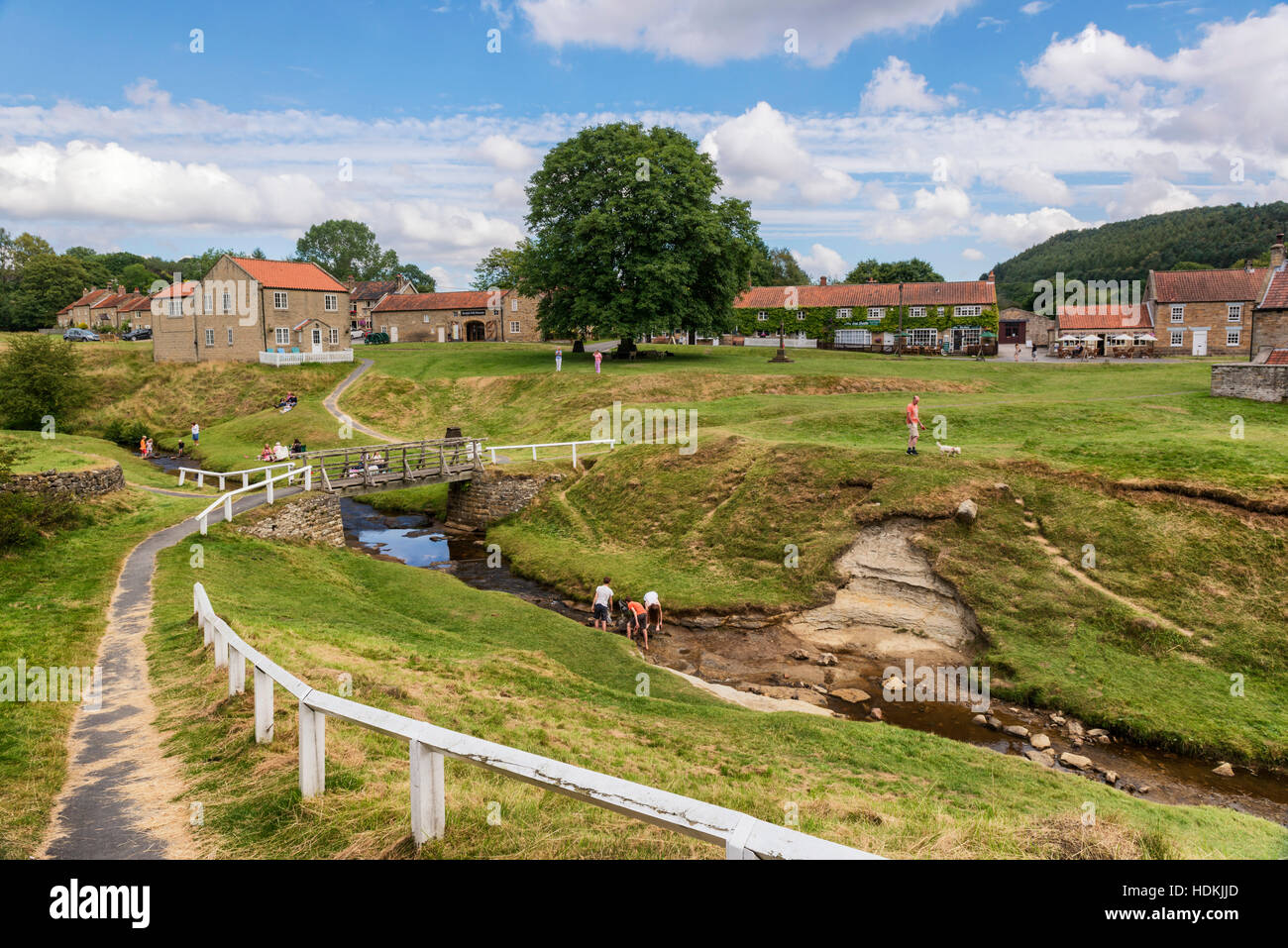 Visitatori godendo di una calda giornata estiva in Hutton Le Hole Village Foto Stock