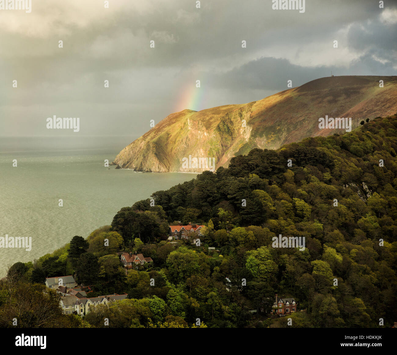 Rainbow su Countisbury Hill cercando su pendio boschivo a Lynton in Devon UK Foto Stock
