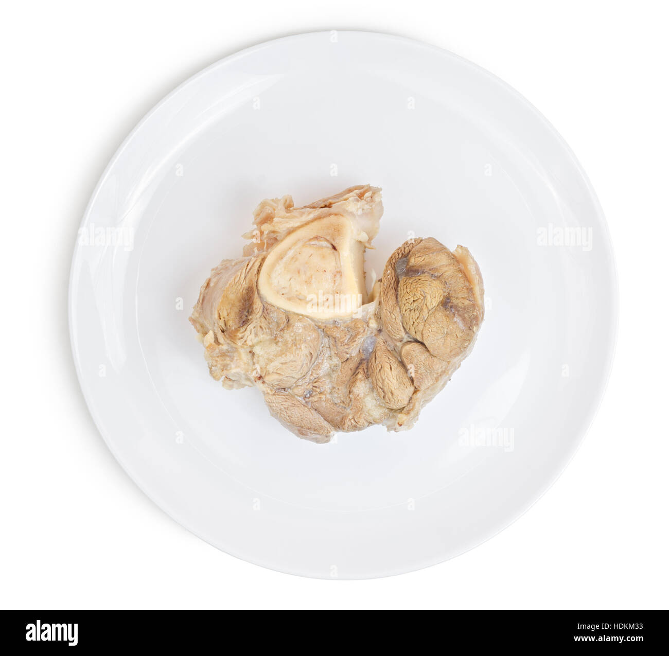 Bollito di maiale con osso sulla piastra isolata su sfondo bianco. Alimenti per animali. Foto Stock