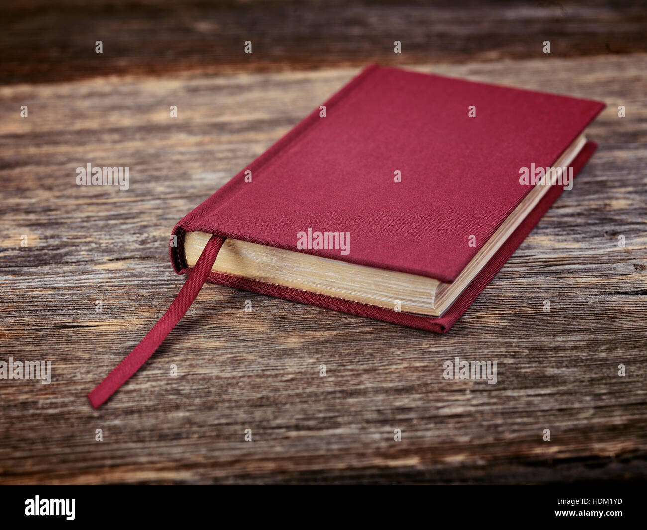 Piccolo rosso libro rilegato sul tavolo di legno sfondo Foto Stock