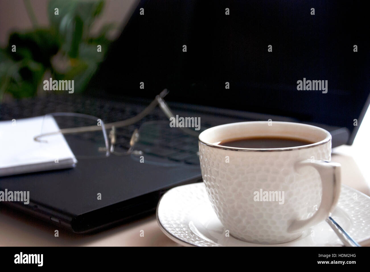 Il computer portatile e la tazza di caffè sulla scrivania Foto Stock