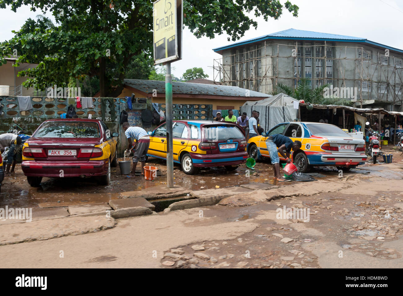 I giovani stanno pulendo le automobili a mano. Lavaggio all'aperto a Freetown, Sierra Leone Foto Stock