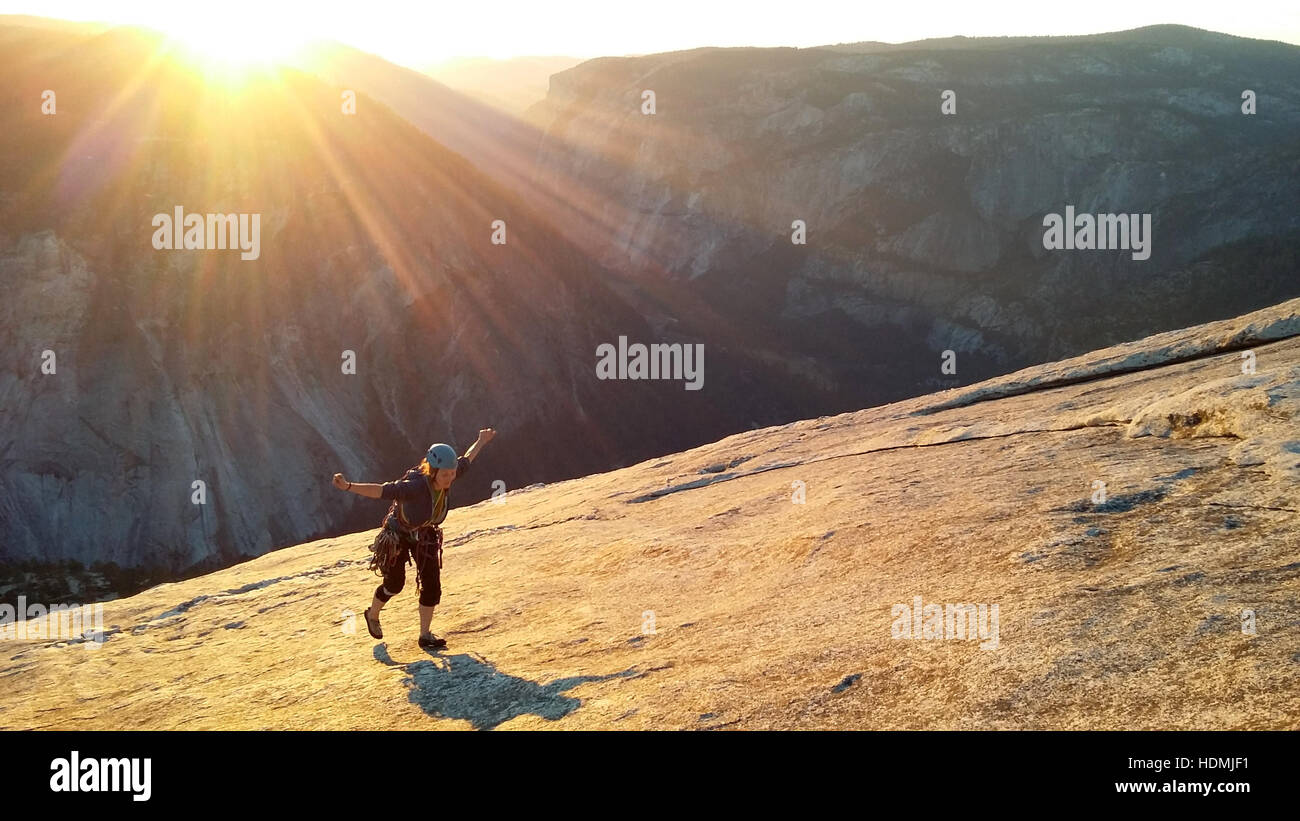 Scalatore femmina topping fuori di Snake Dike al tramonto, Half Dome, il Parco Nazionale di Yosemite Foto Stock