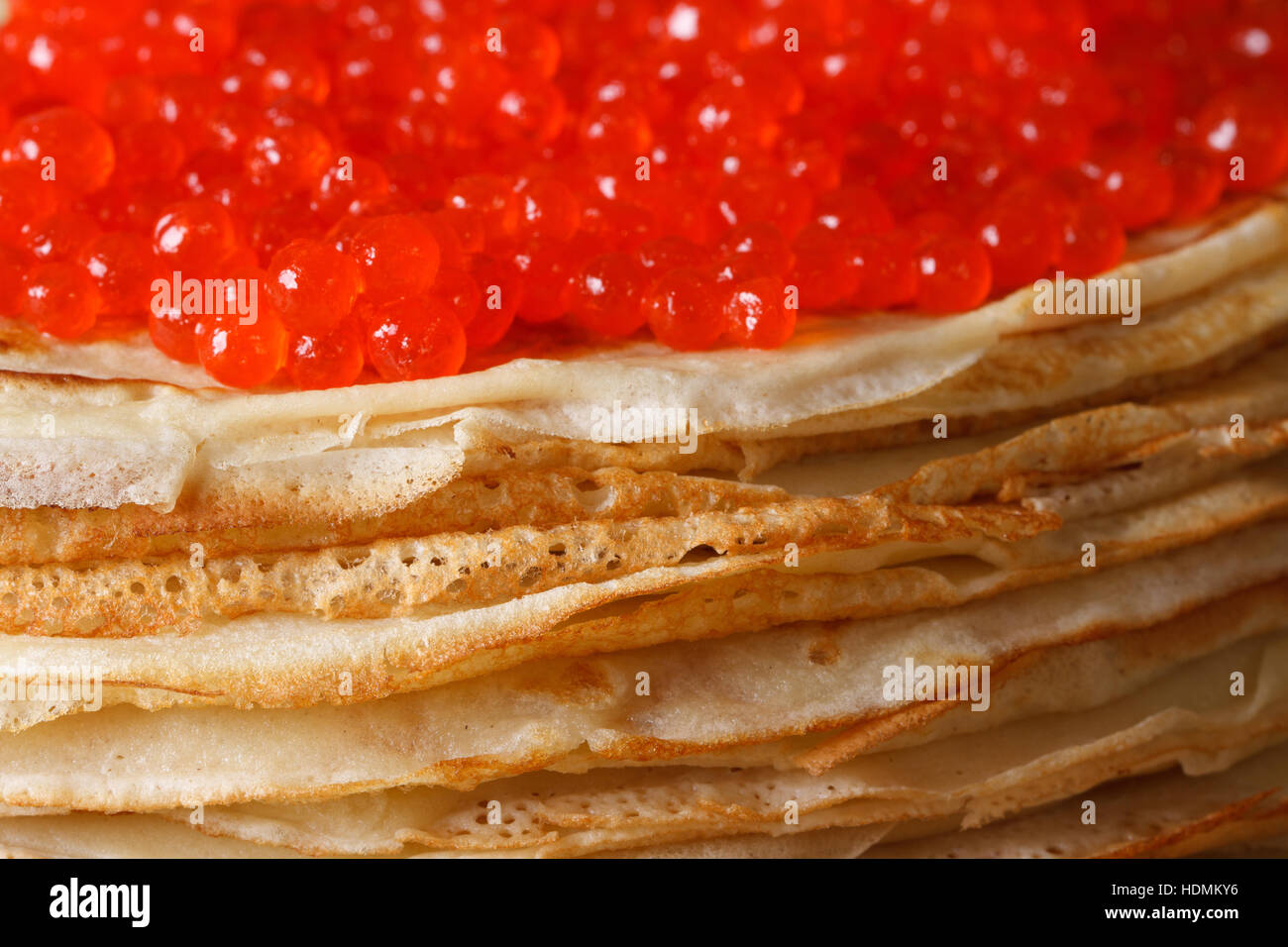 Una pila di sottili crepes con caviale rosso macro. orizzontale, stile rustico Foto Stock