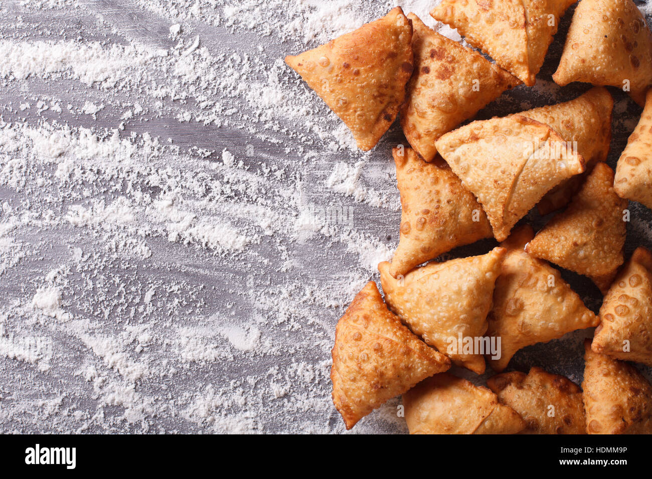 Indian samosa pasticceria su una tavola infarinata. vista orizzontale dal di sopra Foto Stock