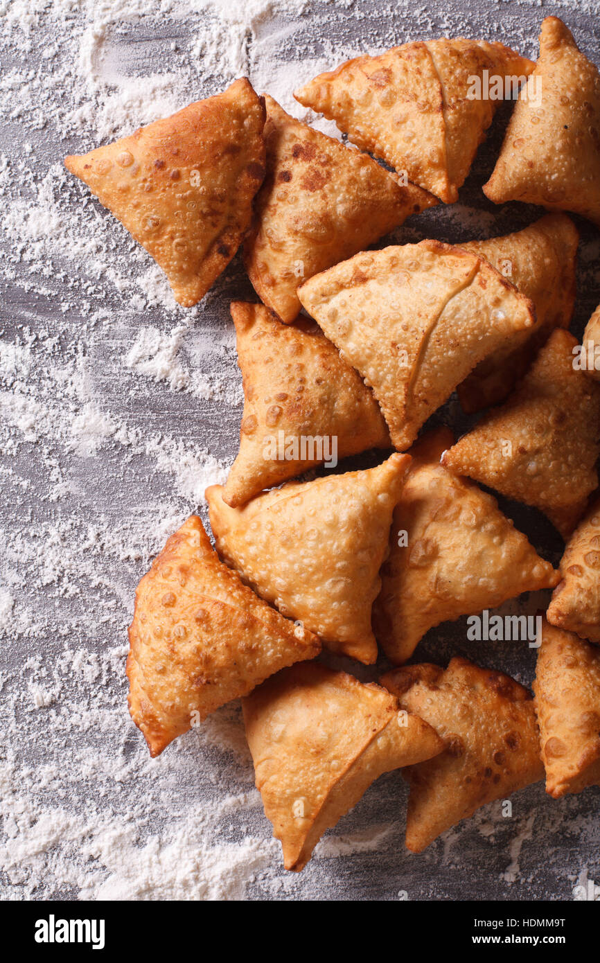 Indian samosa pasticceria su una tavola infarinata. Vista verticale da sopra Foto Stock