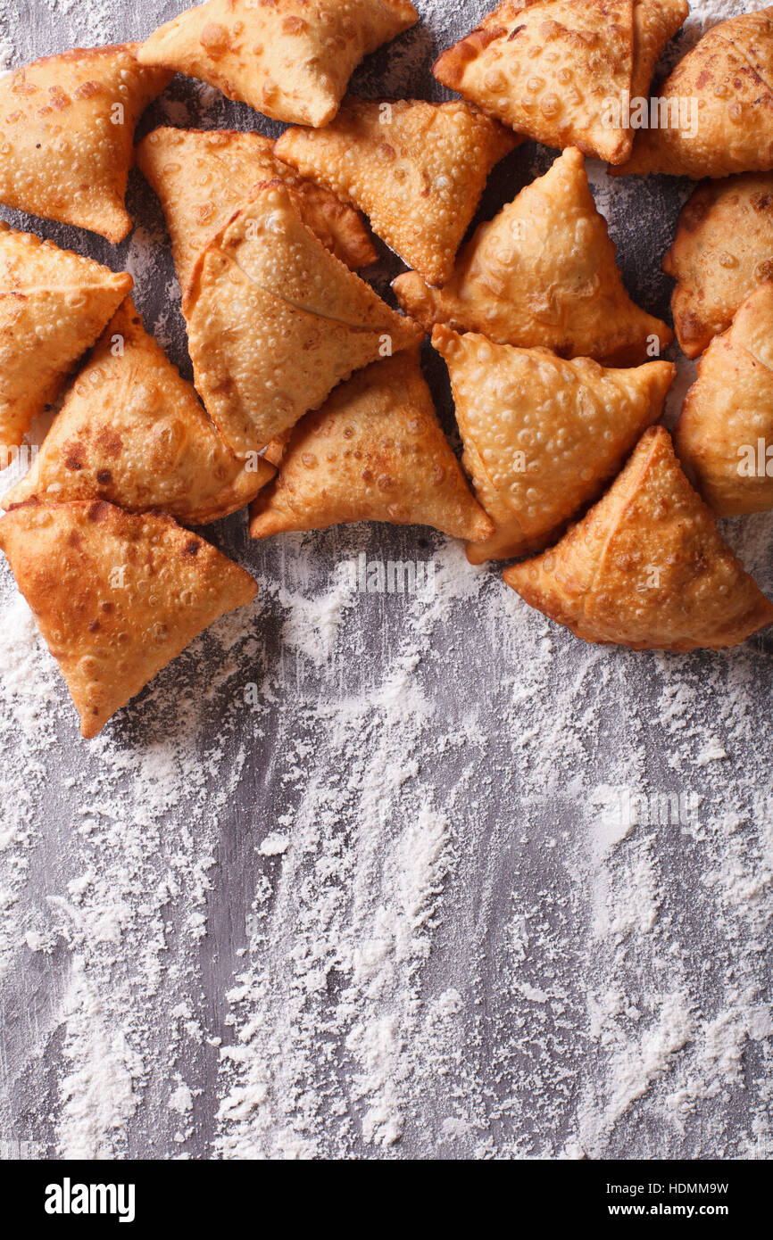 Un mucchio di cottura samosas su un tavolo infarinato. verticale in alto Visualizza ingrandimento Foto Stock