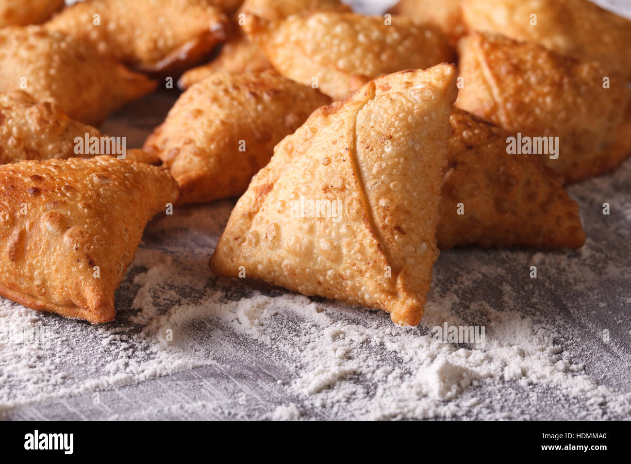 Un mucchio di cottura samosas su un tavolo infarinato. Orizzontale di close-up Foto Stock