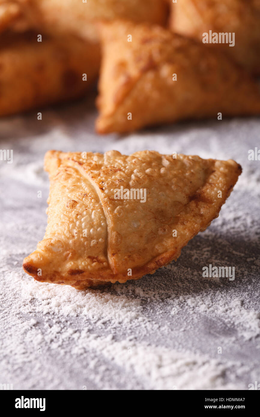Indian samosa pasticceria close-up su una tabella con farina verticale. Foto Stock