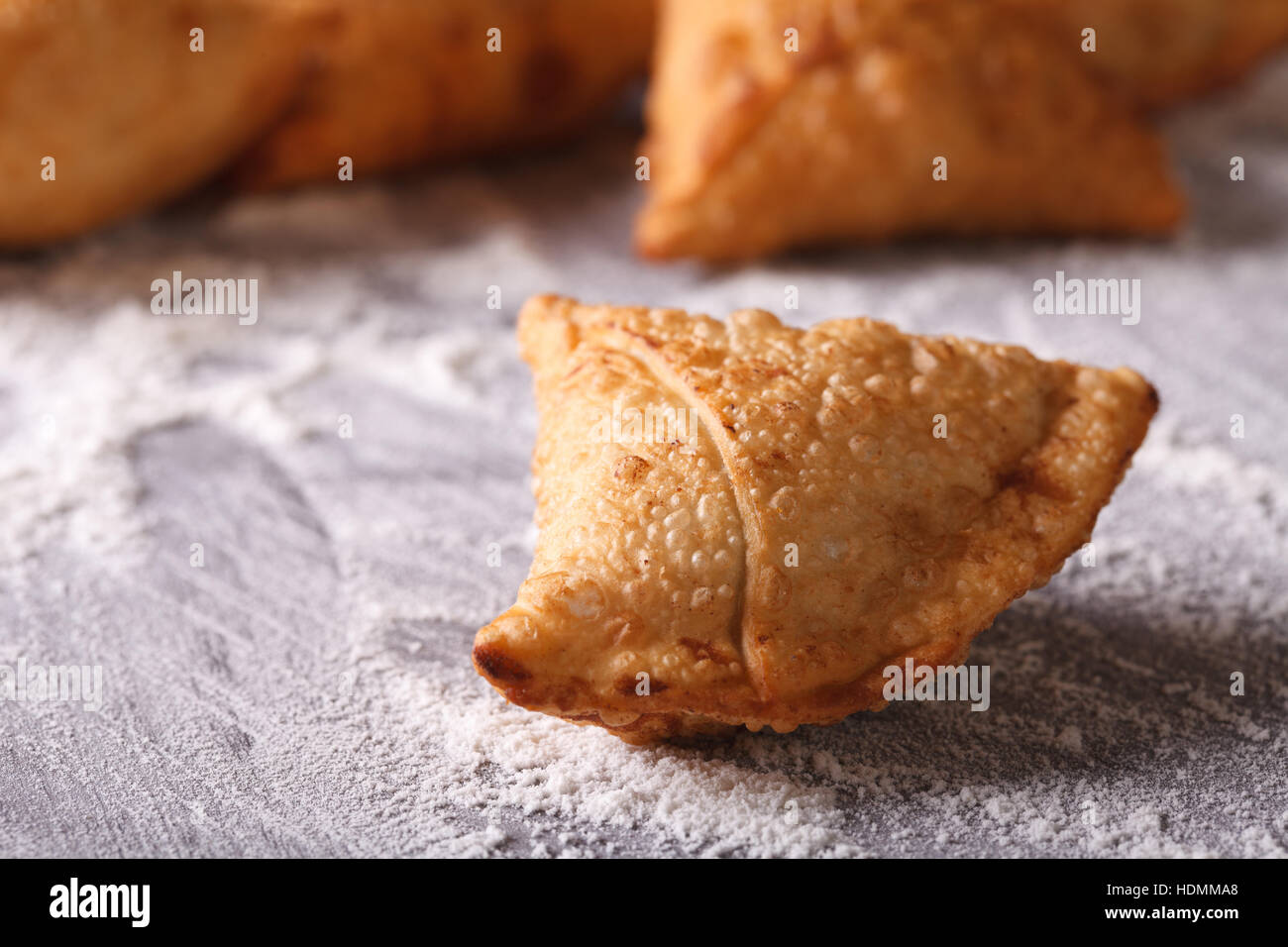 Indian samosa pasticceria close-up su una tabella con farina orizzontale. Foto Stock