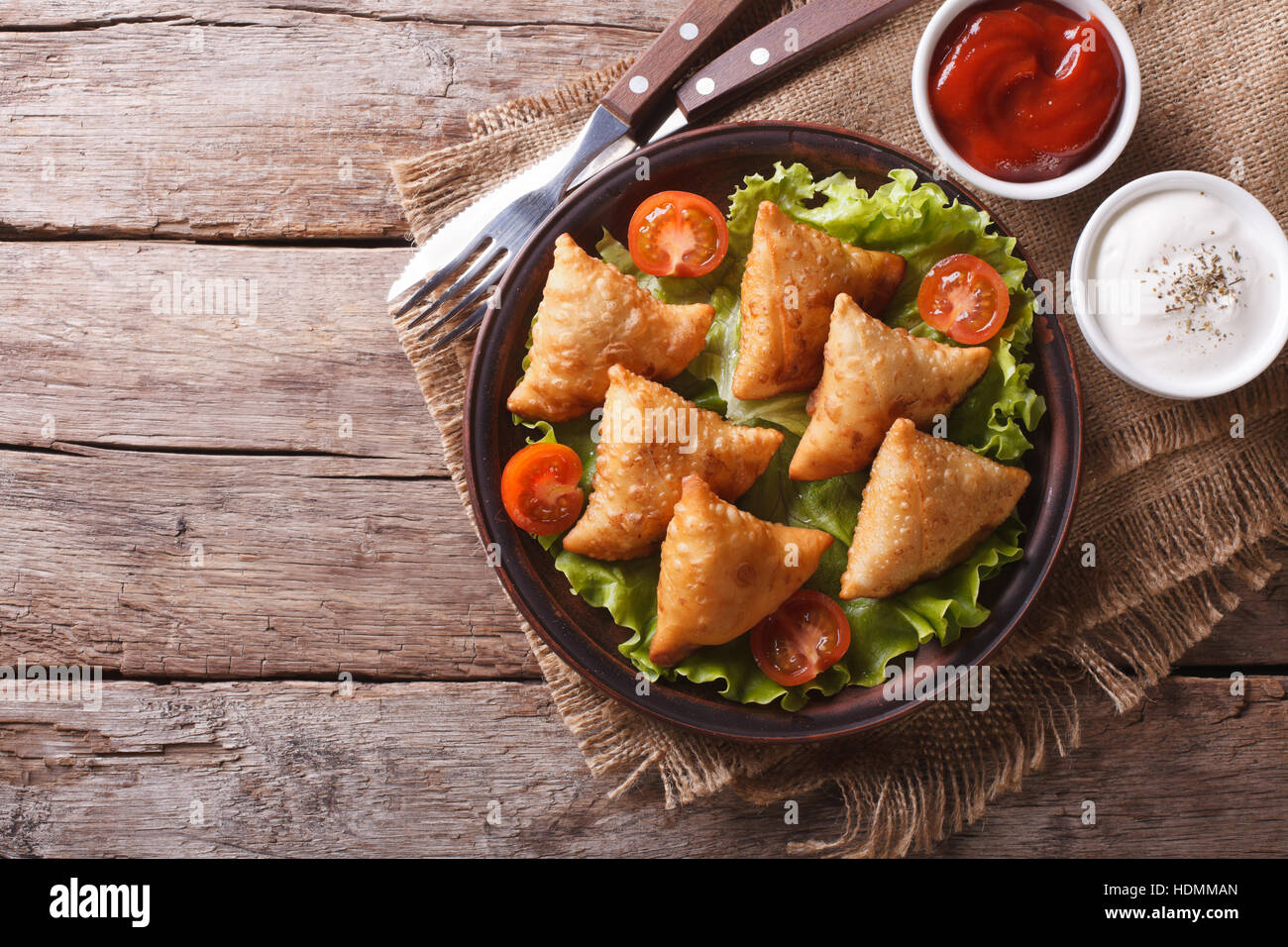 Samosa su una piastra con salsa di pomodori e. vista orizzontale dal di sopra, stile rustico Foto Stock