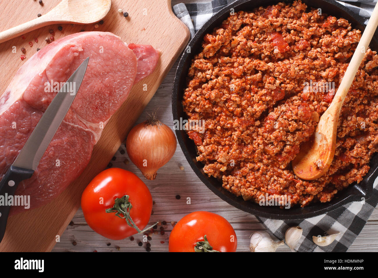 Il ragù alla bolognese in una padella con gli ingredienti sul tavolo. vista orizzontale dal di sopra closeup Foto Stock