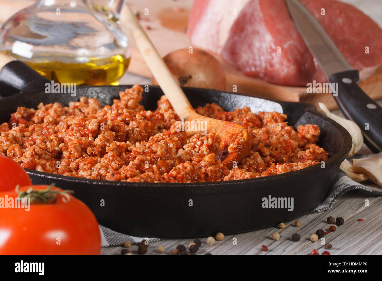 La salsa calda Bolognese in una padella e ingredienti freschi di close-up sul tavolo orizzontale. Foto Stock
