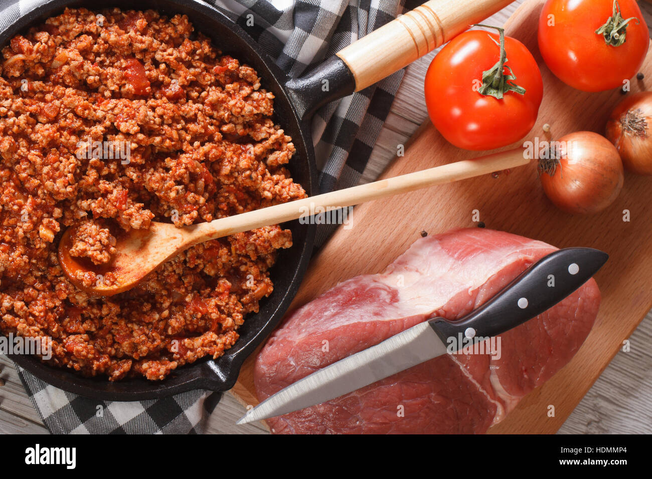 Il ragù alla bolognese in un tegame e gli ingredienti sul tavolo di close-up. vista orizzontale dal di sopra Foto Stock
