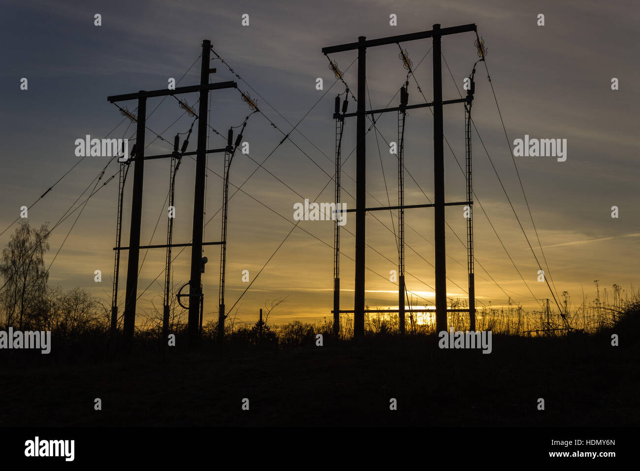 Sagome delle linee di alimentazione in uno scenario al tramonto Foto Stock