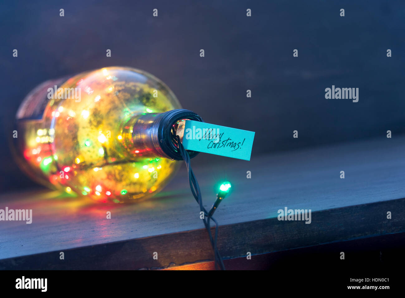Buon Natale tag e bottiglia con una ghirlanda di fiori Foto Stock Buon Natale tag e bottiglia con una ghirlanda di fiori Foto Stock