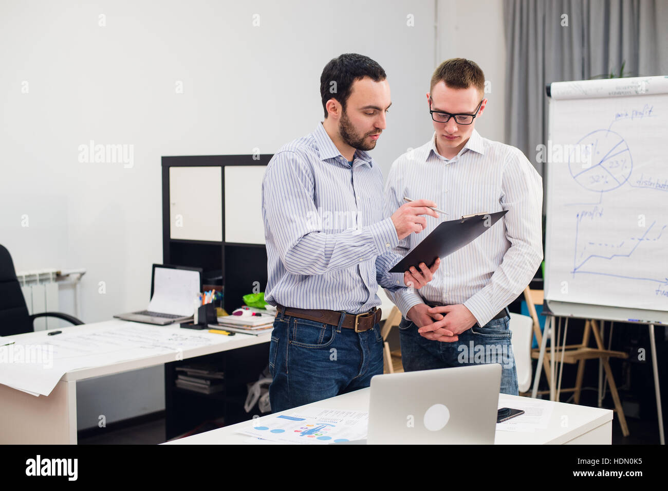 Due caucasici i dirigenti aziendali in abbigliamento casual avente una discussione aziendale in ufficio. Foto Stock