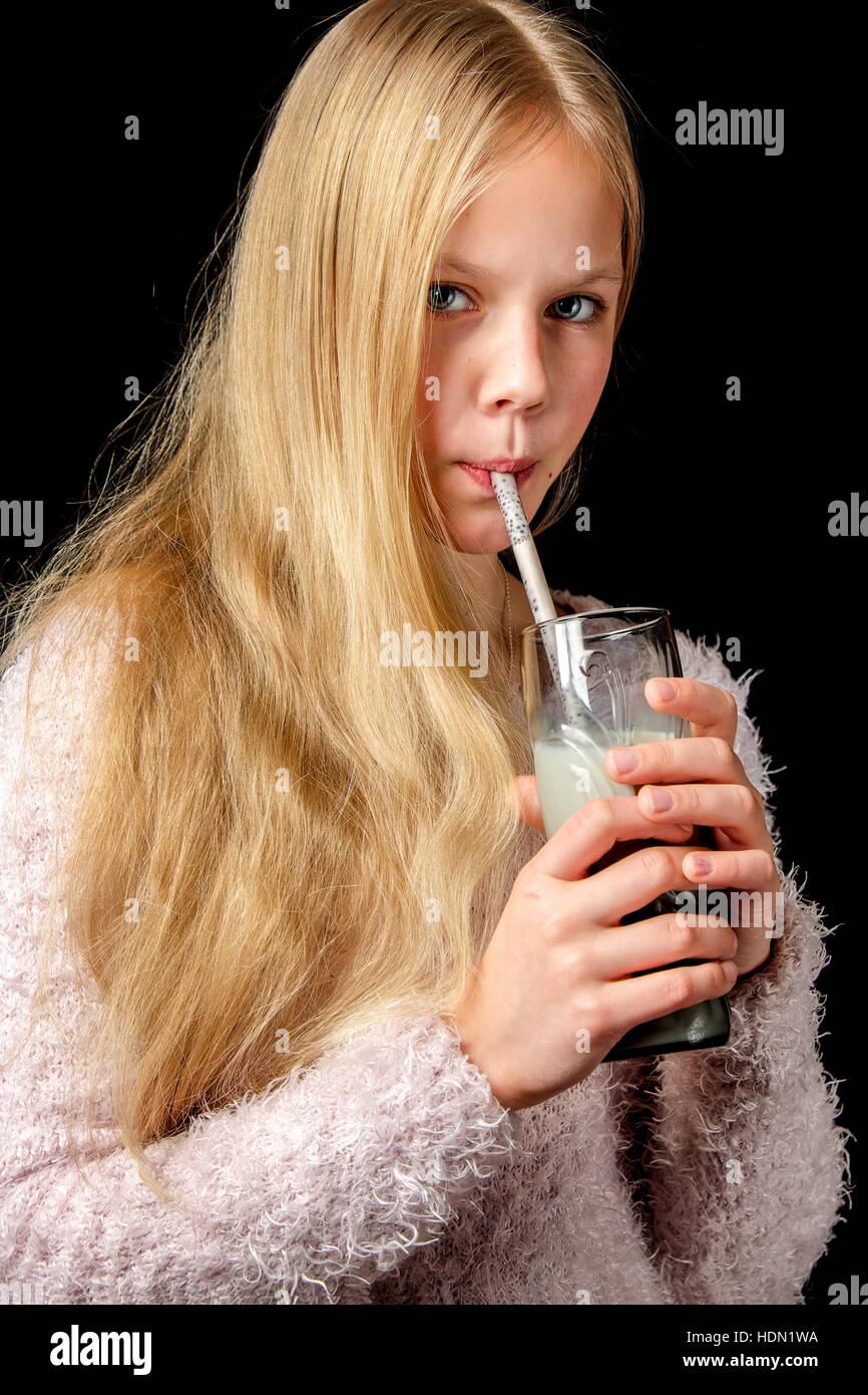 Capelli biondi ragazza bere latte shake attraverso la paglia di cacao Foto Stock
