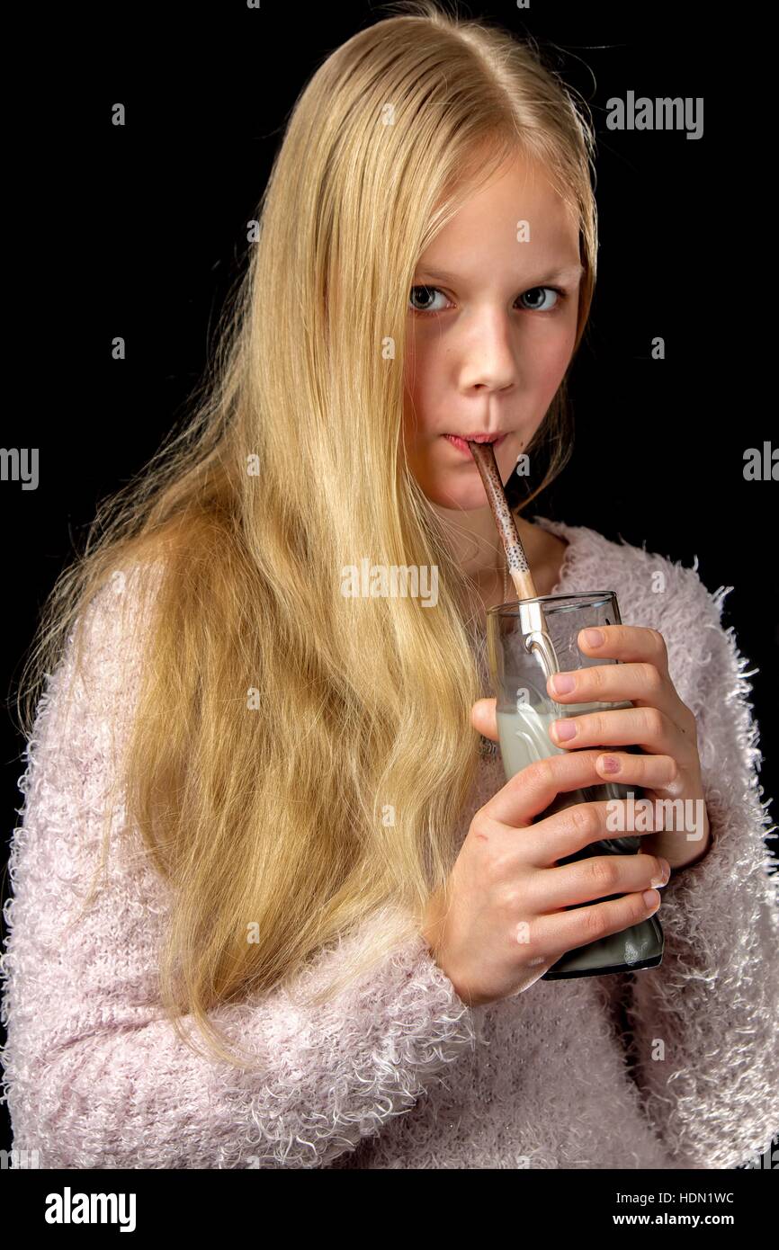 Capelli biondi ragazza bere latte shake attraverso la paglia di cacao Foto Stock