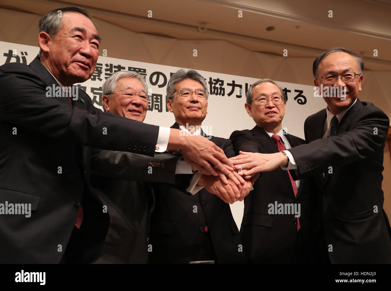 Tokyo, Giappone. Xiii Dec, 2016. (L-R) Mitsubishi Electric presidente Masaki Sakuyama, Hitachi presidente Hiroaki Nakanishi, Istituto Nazionale per il Quantum e scienze radiologiche e tecnologia (QST) presidente Toshio Hirano, Toshiba presidente Satoshi Tsunakawa e Sumitomo Heavy Industries presidente Shunsuke Betsukawa agitare le mani come hanno firmato un accordo di cooperazione globale sulla quinta generazione fascio Quantum Cancer Facility a Tokyo il Martedì, Dicembre 13, 2016. QST e altre quattro imprese piani per sviluppare il bisturi quantistica utilizzando le tecnologie di accelerazione laser e supe Foto Stock