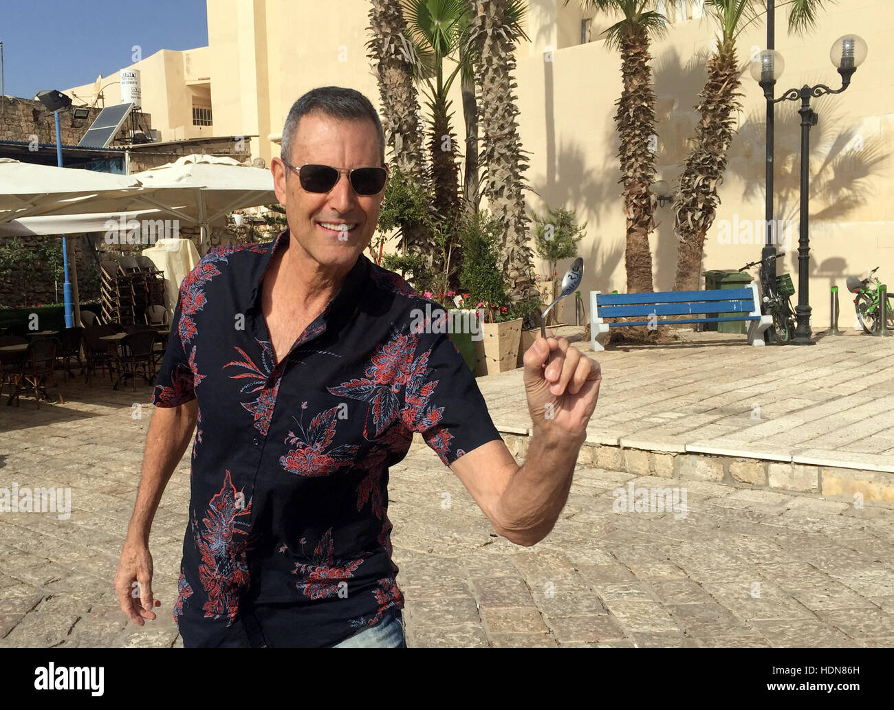 Tel Aviv, Israele. 23 Nov, 2016. Illusionista Uri Geller raffigurata con un cucchiaio ha piegato, vicino alla sua casa nella città vecchia di Tel Aviv, Israele, 23 novembre 2016. Foto: Sara Lemel/dpa/Alamy Live News Foto Stock