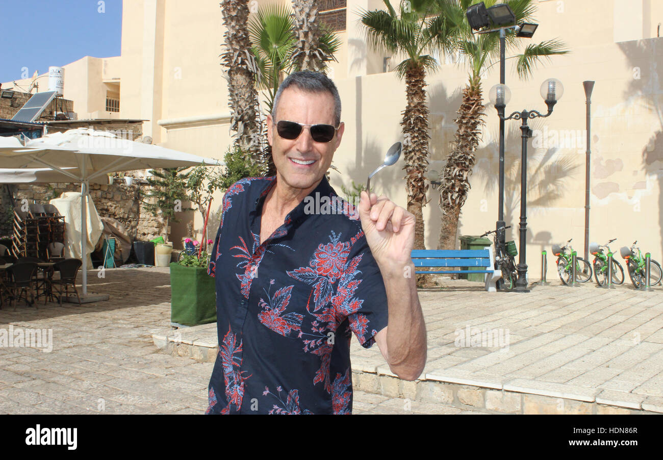 Tel Aviv, Israele. 23 Nov, 2016. Illusionista Uri Geller raffigurata con un cucchiaio ha piegato, vicino alla sua casa nella città vecchia di Tel Aviv, Israele, 23 novembre 2016. Foto: Sara Lemel/dpa/Alamy Live News Foto Stock