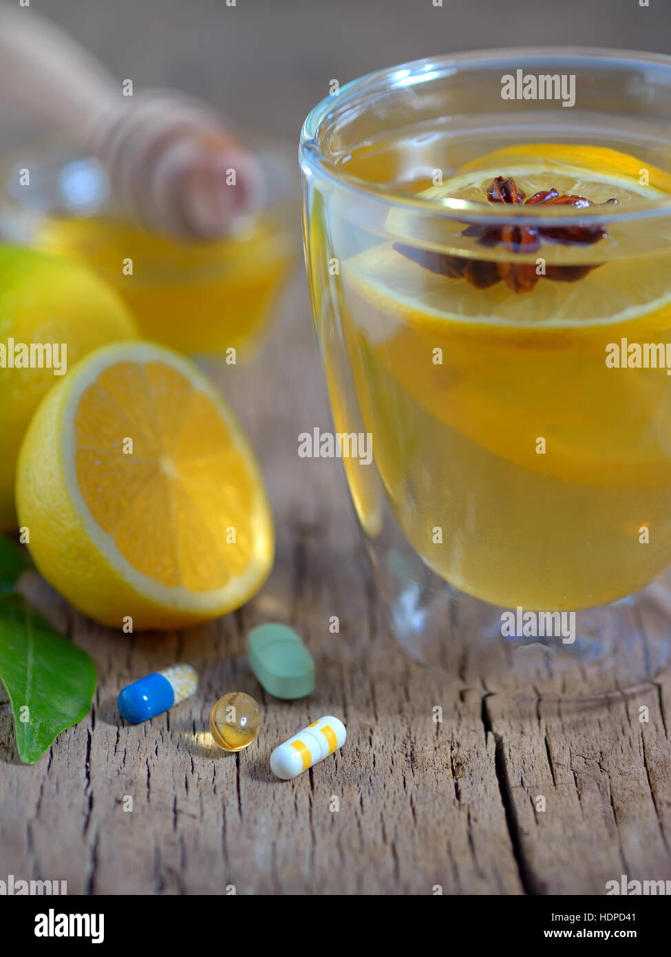 Hot tè al limone e pillole sul tavolo di legno Foto Stock