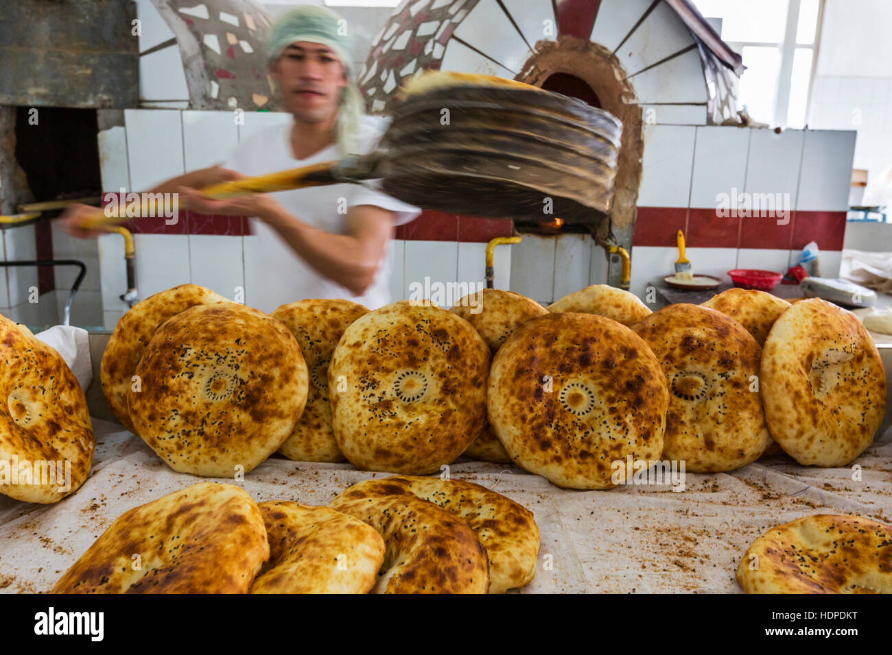 La produzione di pane in una panetteria nel bazaar Chorsu a Tashkent, Uzbekistan. Foto Stock