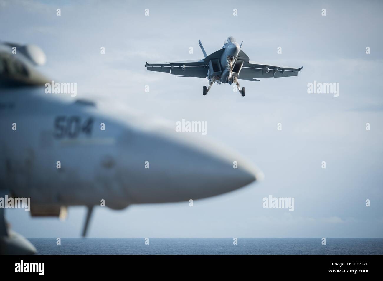 Un Boeing F/A-18E Super Hornet multi-ruolo di aerei da combattimento si prepara a terra sul ponte di volo dell'USN Nimitz-classe-nucleare powered supercarrier USS John C. Stennis Novembre 26, 2016 nell'Oceano Pacifico. Foto Stock