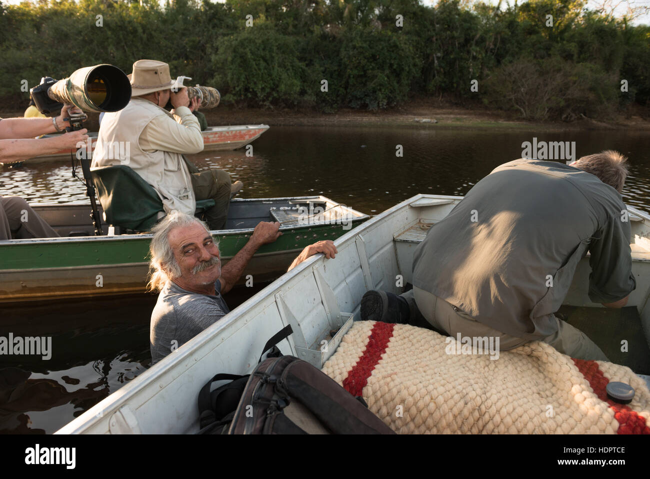 Eco turisti fotografare una Jaguar in Sud Pantanal mentre una guida locale si sforza di mantenere le barche in posizione. Foto Stock