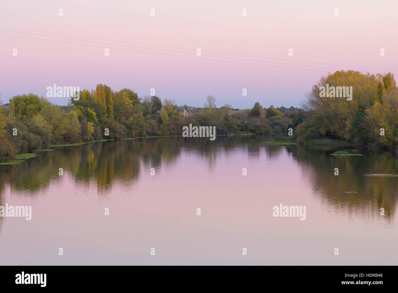 La riflessione di acqua al tramonto nel fiume Alagon in Coria (Estremadura, Spagna). Foto Stock