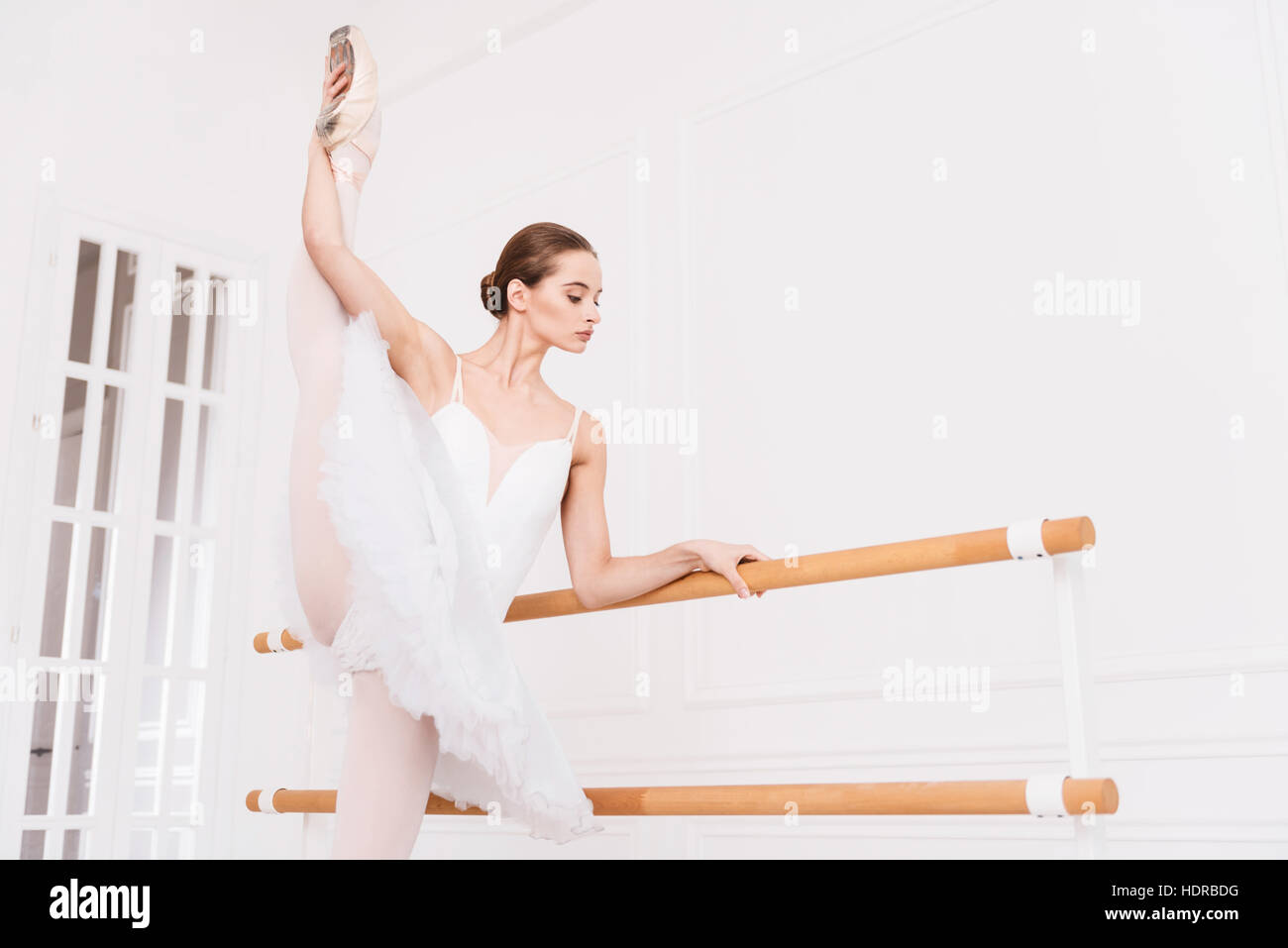 Elegante ballerina classica toccando il suo piede nell'aria Foto Stock