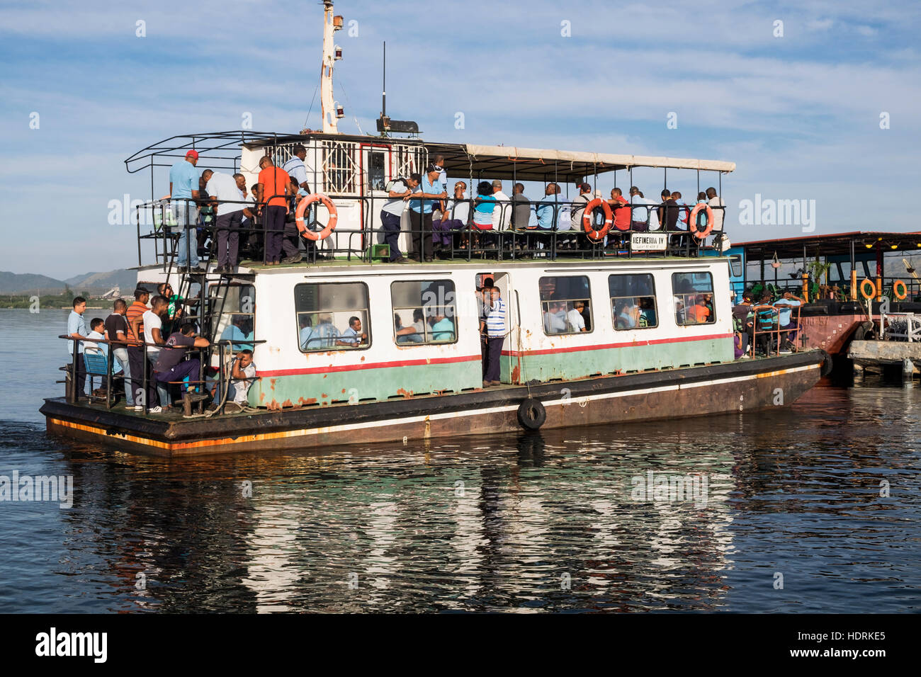 I lavoratori a bordo di un traghetto prendere al loro posti di lavoro presso la raffineria di Santiago de Cuba, Cuba Foto Stock