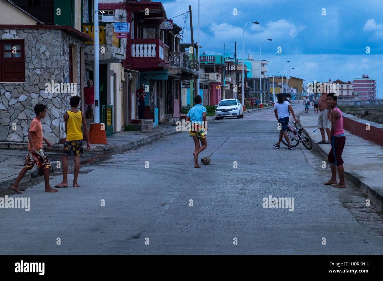 I bambini giocano a calcio a piedi nudi in strada, Baracoa, Cuba Foto Stock
