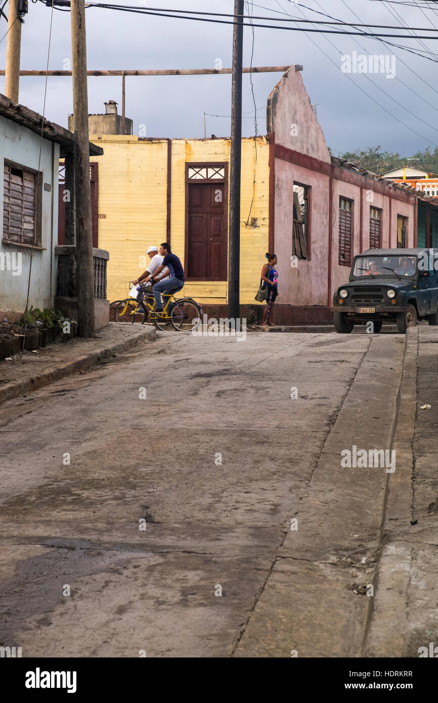 Angolo di strada la mattina presto la gente va a lavorare e edificio danneggiate in uragano Mathew, Baracoa, Cuba Foto Stock