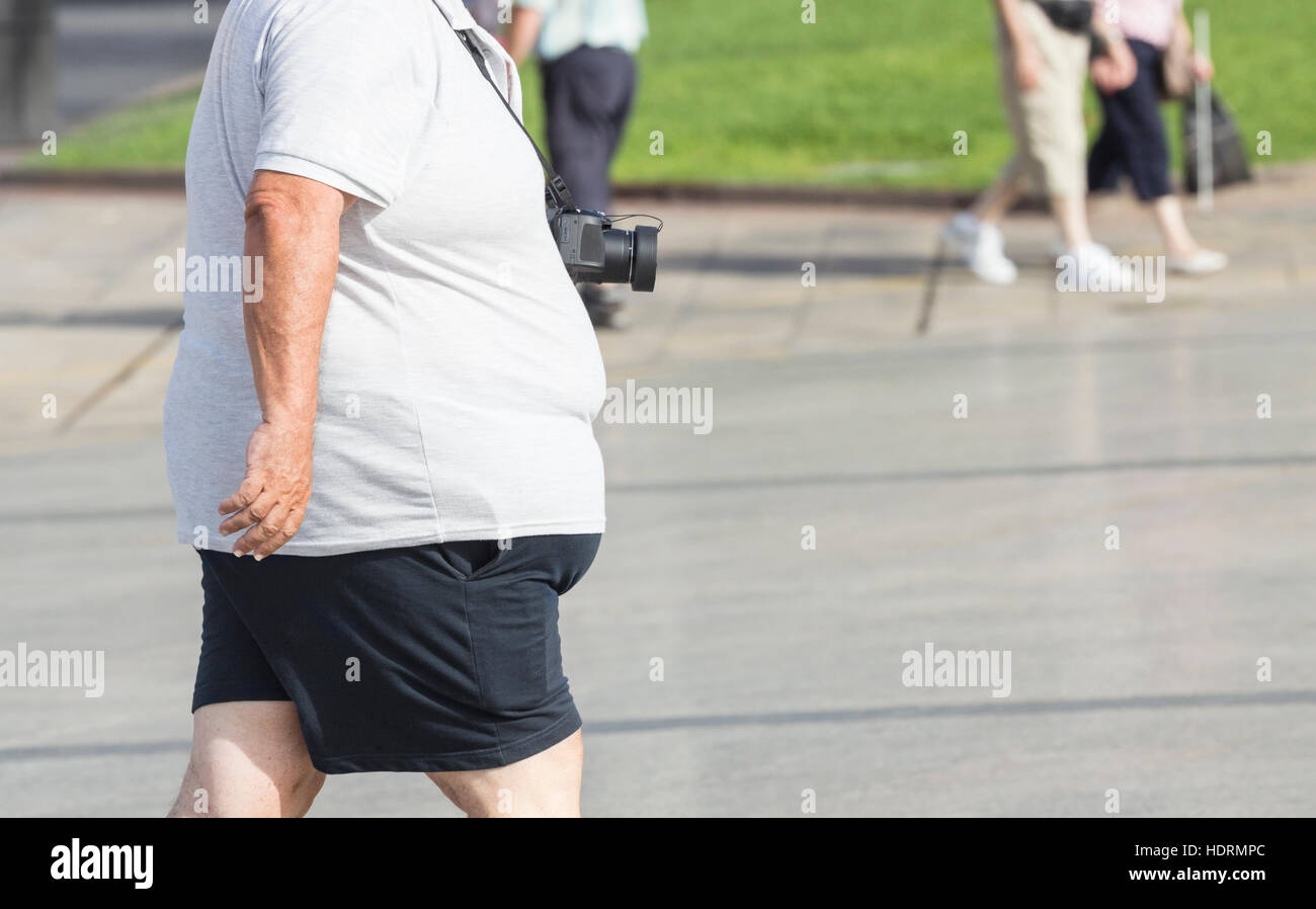 Il sovrappeso turistico con fotocamera. Foto Stock