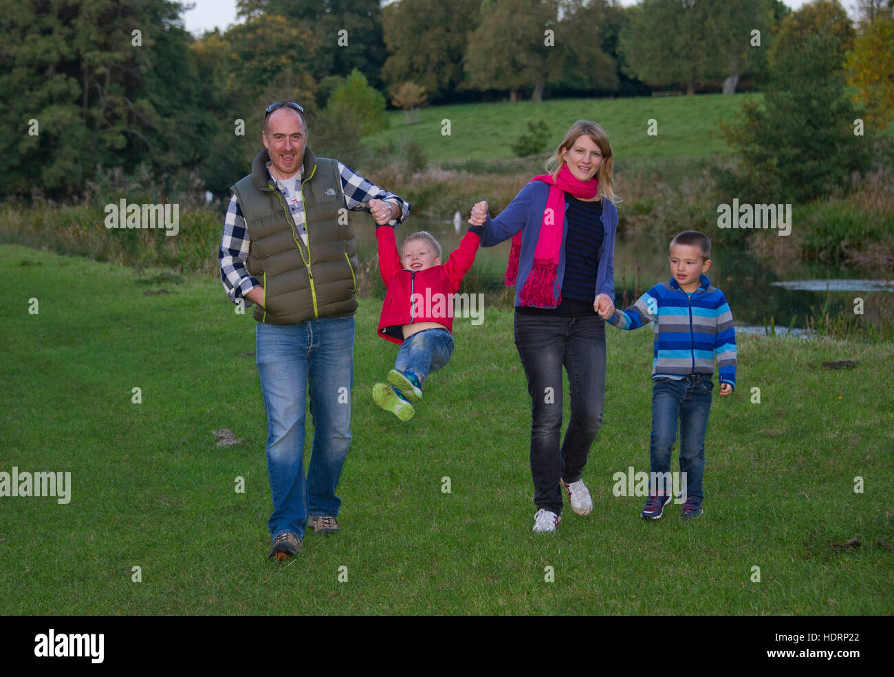 Una famiglia giovane con la madre, padre e 2 giovani ragazzi, passeggiate in campagna. Foto Stock