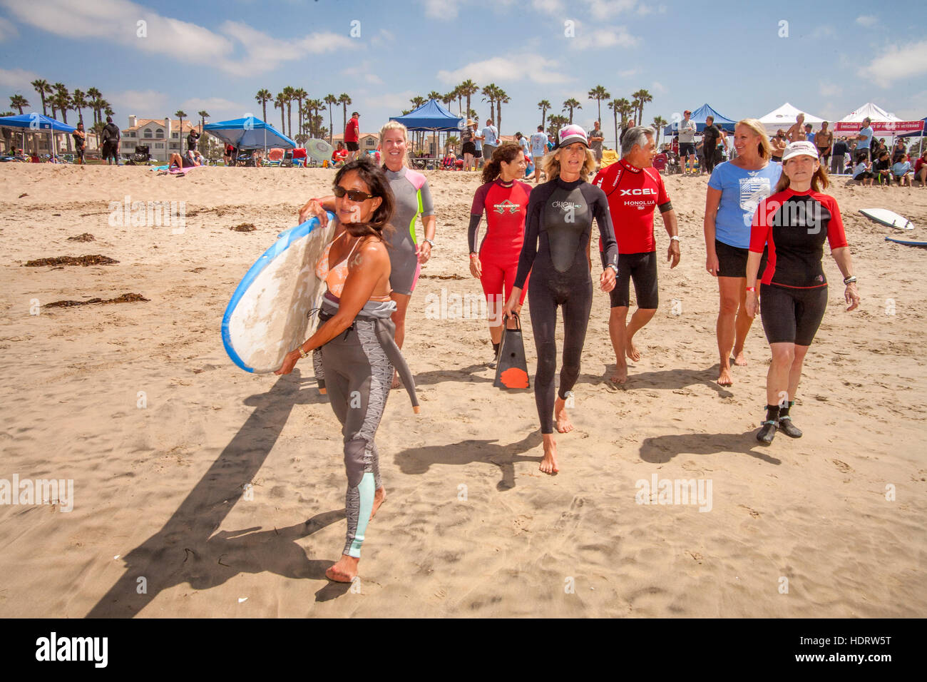 Grazie per il suo servizio militare, un veterano (centro destra) riceve gratuitamente una lezione di surf da un istruttore femmina come essi a piedi l'Oceano Pacifico in Huntington Beach, CA. Foto Stock