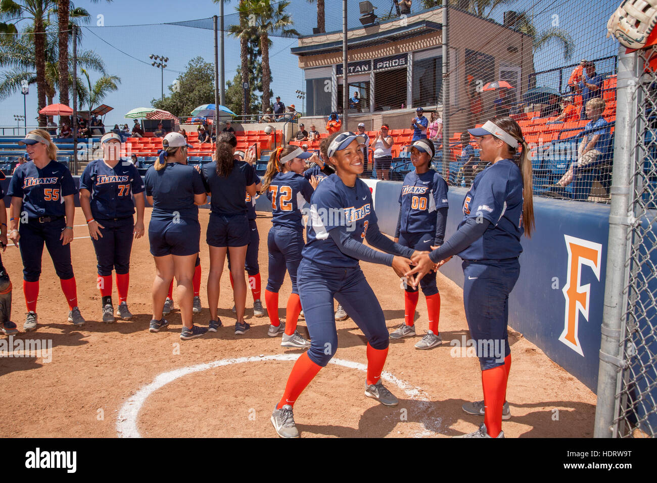 Multirazziale college femminile giocatori di softball preparare per un gioco sul campo in Fullerton, CA. Foto Stock
