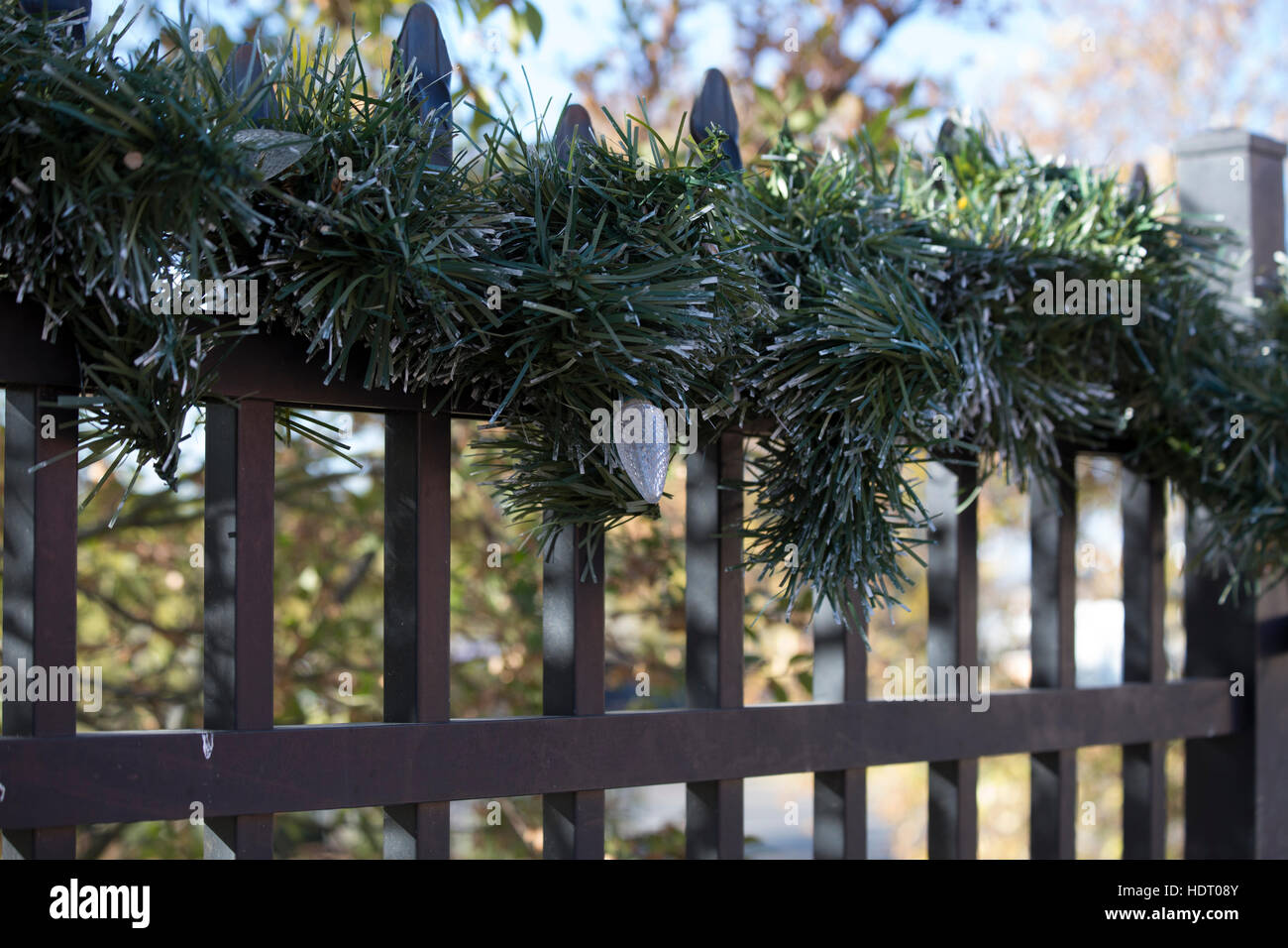 Le luci di Natale e la ghirlanda su una recinzione Foto Stock