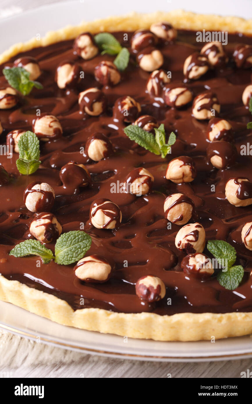 Crostata con cioccolato e nocciole su una piastra su un tavolo di close-up.verticale Foto Stock