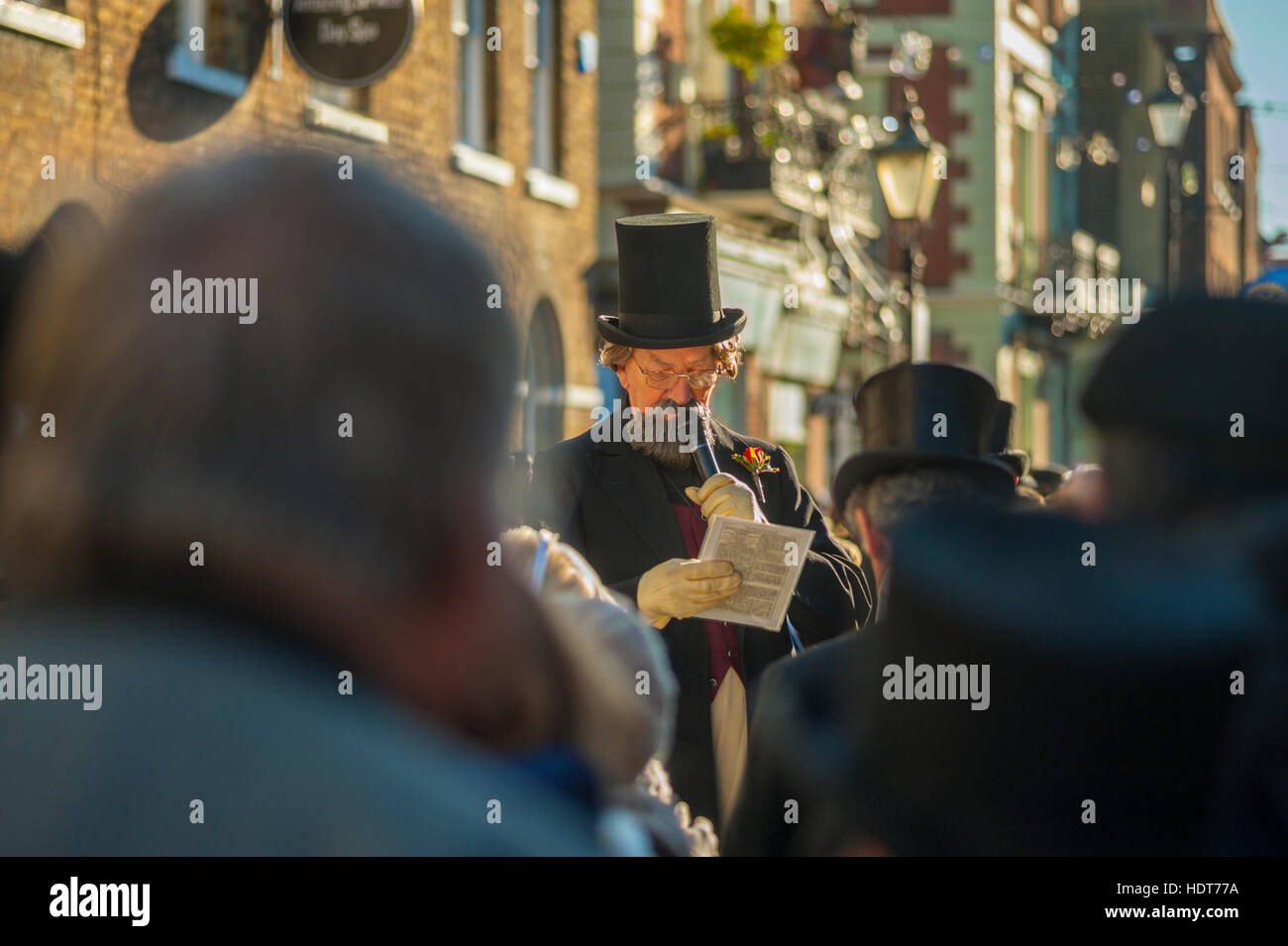 Attore vestito come Charles Dickens lettura per la folla della 2016 Dickensian Festival di Natale in Rochester Kent Foto Stock